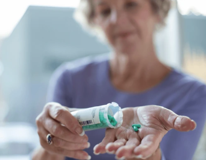 woman pouring pills from bottle
